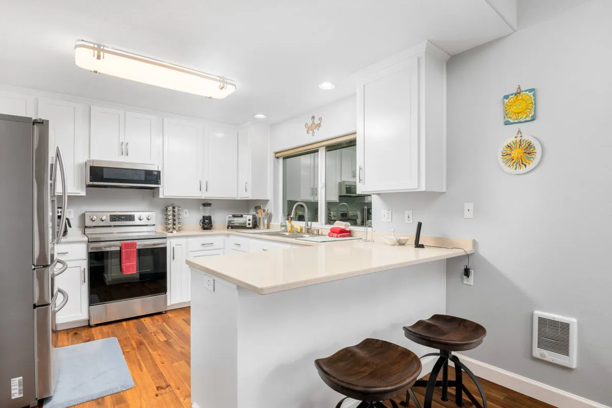 A modern, chef-ready kitchen with a central island, stylish bar stools, and state-of-the-art appliances. The layout encourages both culinary creativity and social interaction, perfectly suited for home-cooked meals and entertaining.