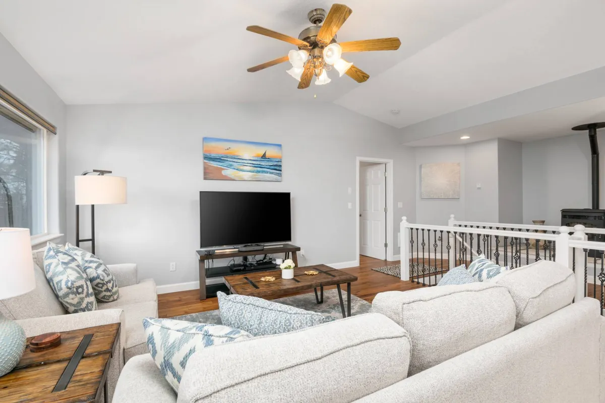 A comfortable living area with a sofa, TV, painting, and coffee table, arranged to encourage both relaxation and socializing. The lighting and layout make it feel ideal for watching movies or casual conversations.